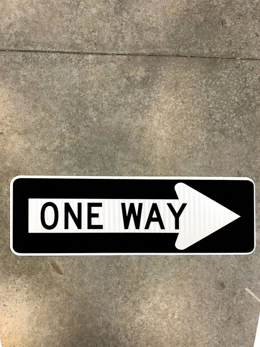 Black and white One Way directional arrow sign