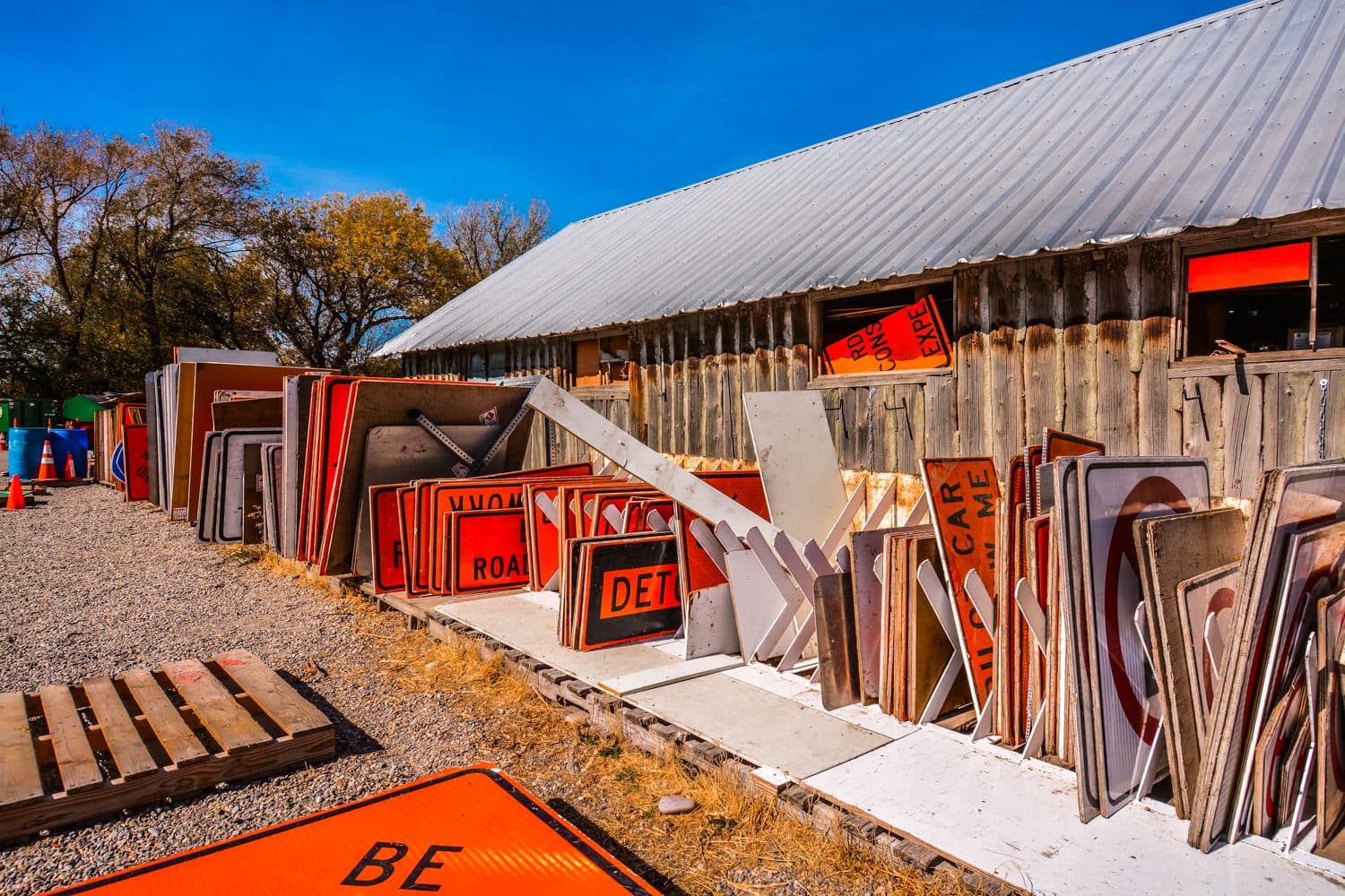 Construction and road signs stacked along the shed in the Idaho Traffic Safety sign yard