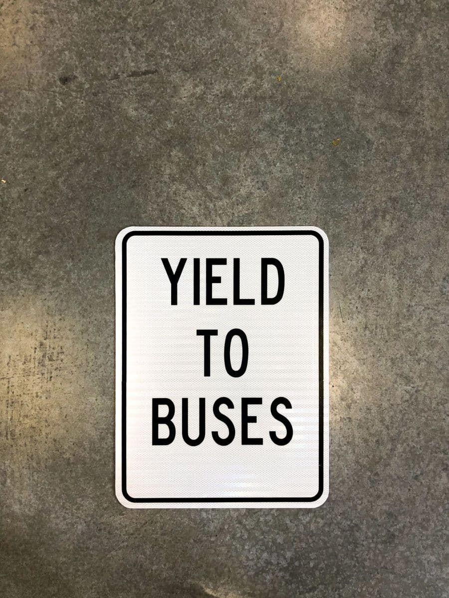 White regulatory “Yield to Buses” sign